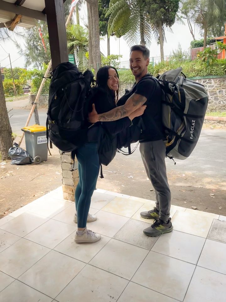 ruta por indonesia dos personas cogidas de los brazos una enfrente de la otra con dos maletas en la espalda